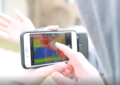 Student studying a thermal image on a cell phone