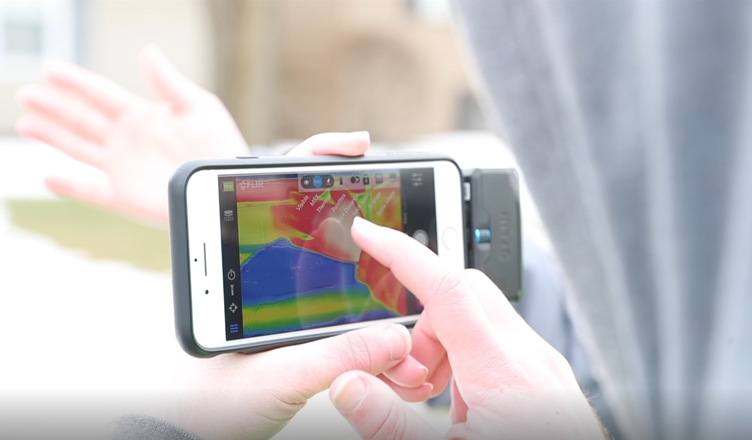 Student studying a thermal image on a cell phone