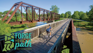 Biker crossing a bridge on the Cardinal Greenway