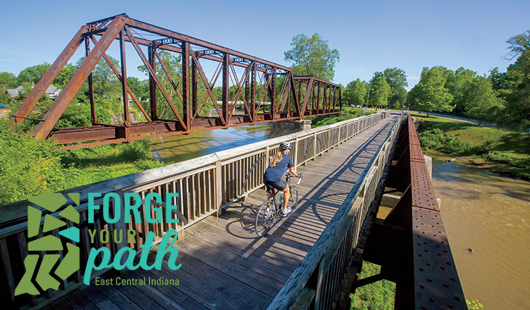 Biker crossing a bridge on the Cardinal Greenway