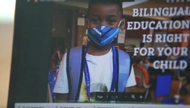 Screenshot of video showing a laptop screen advertising dual language education