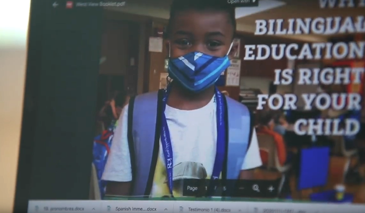Screenshot of video showing a laptop screen advertising dual language education