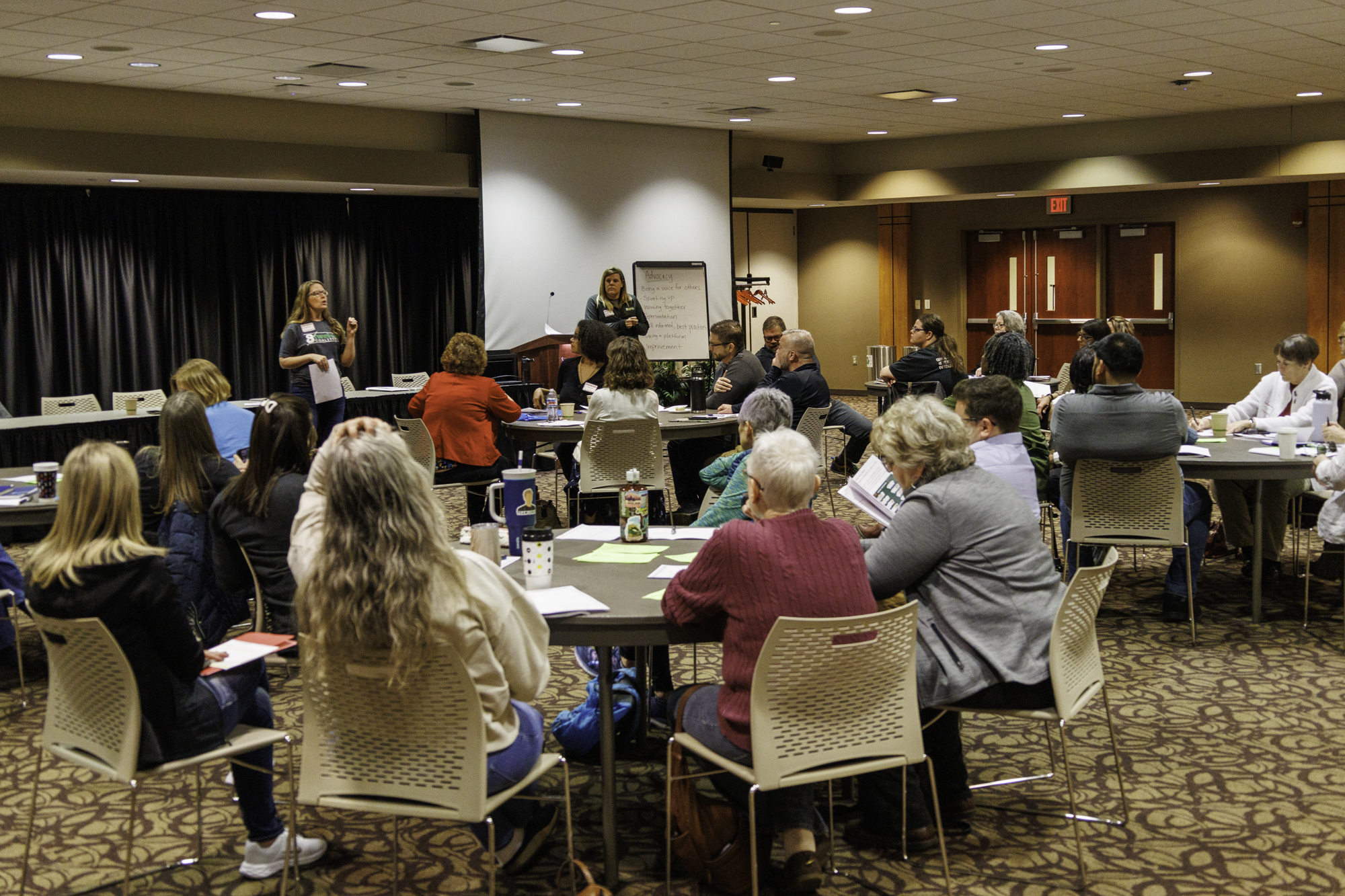 A room full of IDEA conference goers listens to a pair of women speaking in a breakout session